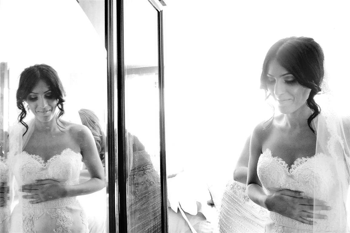 astonishing wedding getting ready bridesmaid helps bride dressing mirror reflection black white photo by lavimage montreal