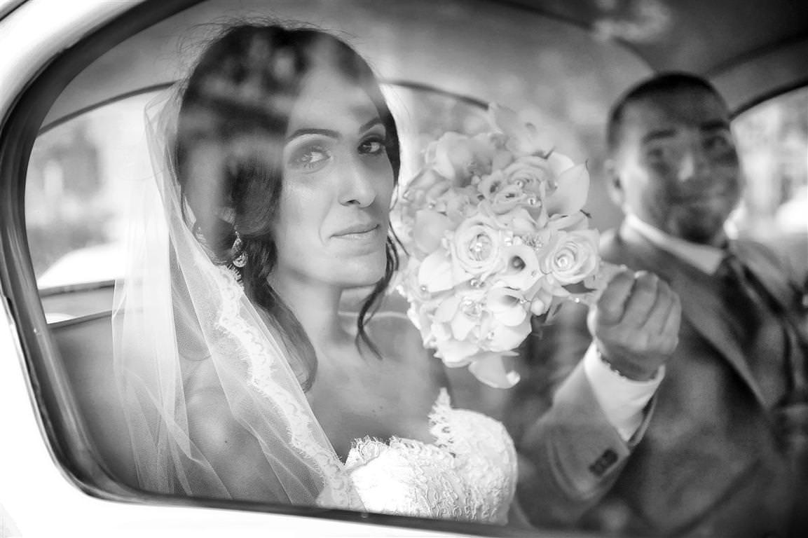 astonishing wedding couple together glance from car window black white artistic shot by lavimage montreal