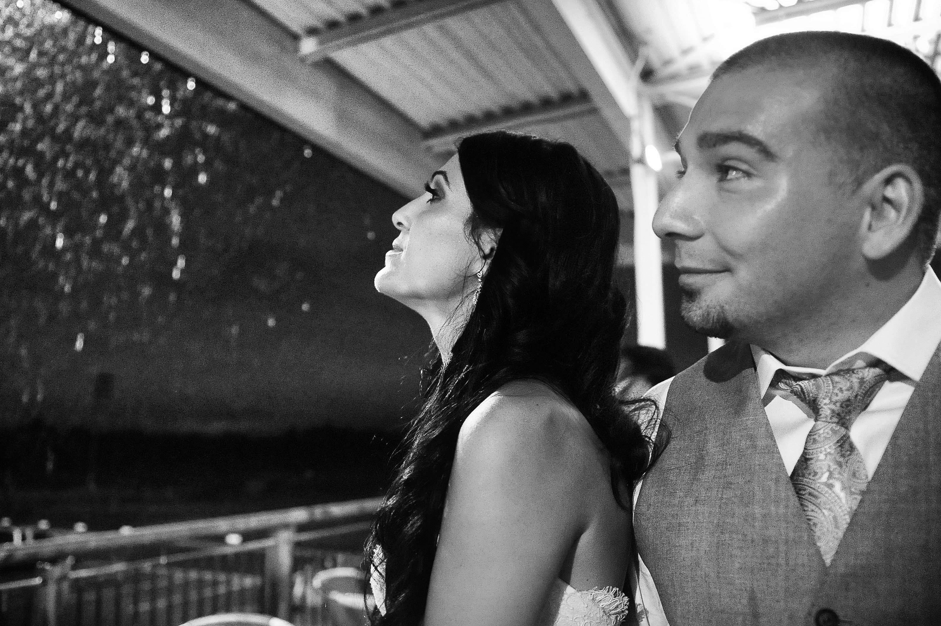 astonishing wedding reception couple together watch fireworks on balcony black white photo by lavimage montreal