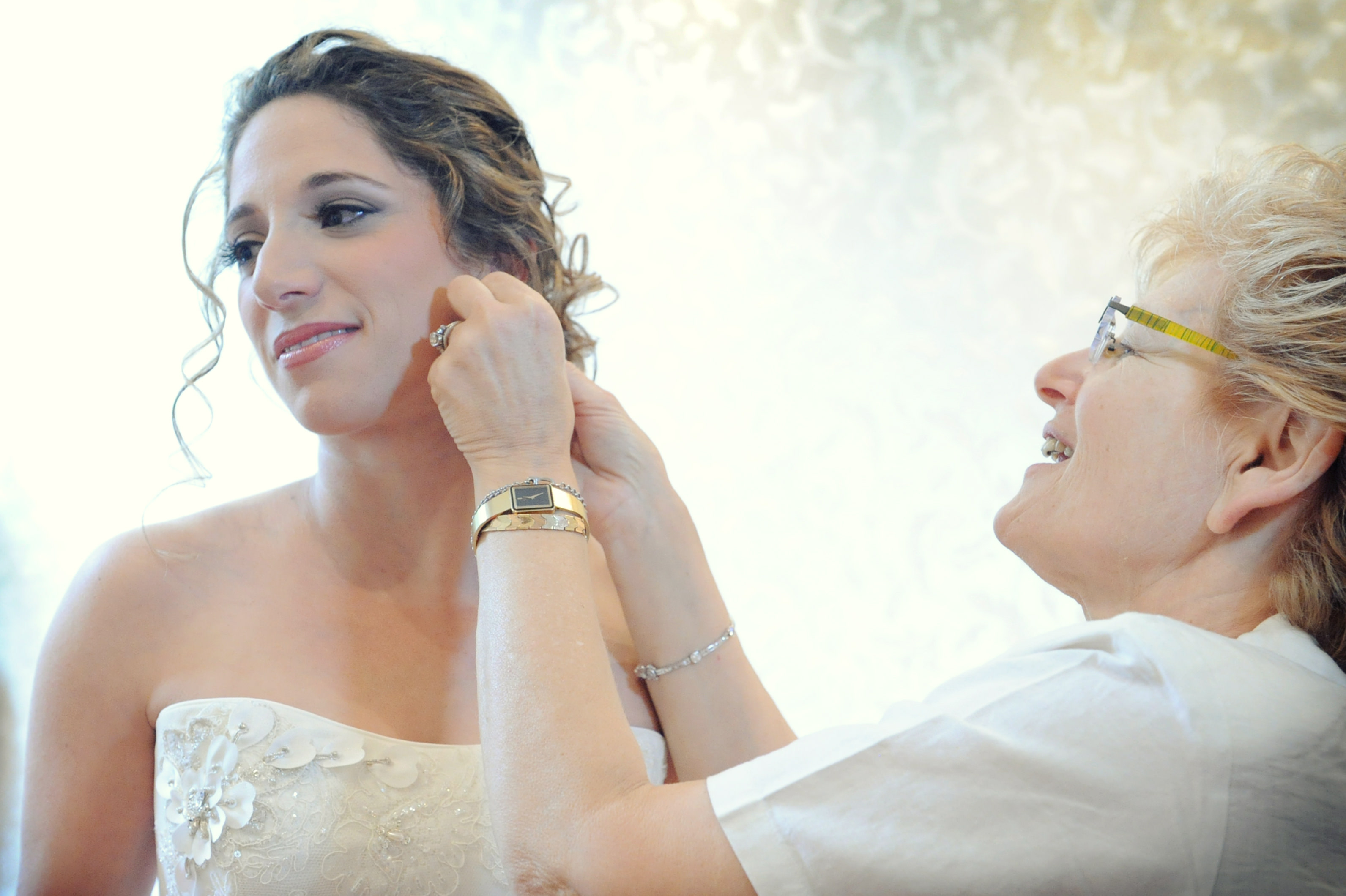 charming wedding getting ready relative helps bride with ear-rings colored wedding photo by lavimage montreal