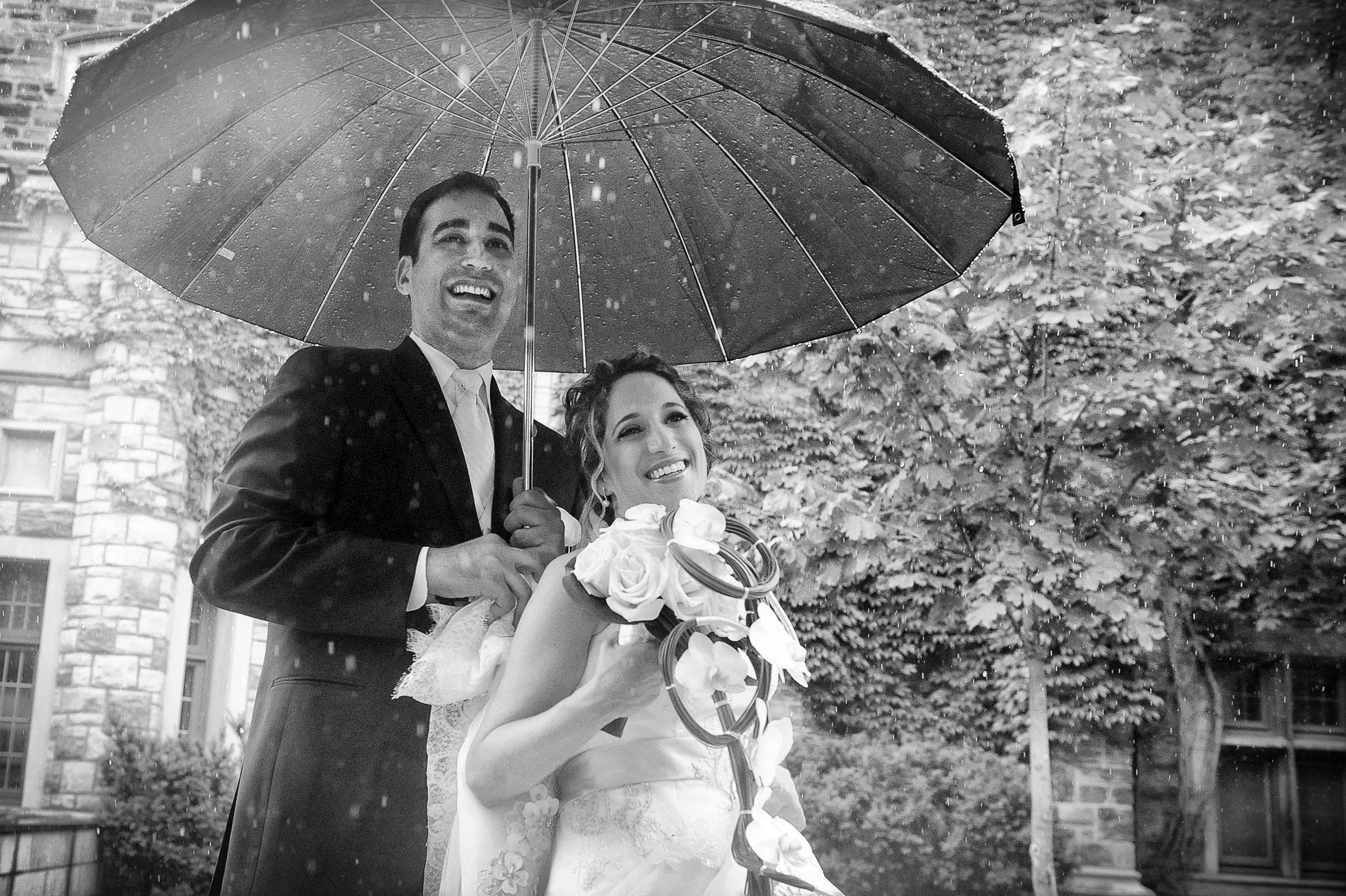 charming wedding couple together romantic walk under rain with umbrella black white artistic shot by lavimage montreal