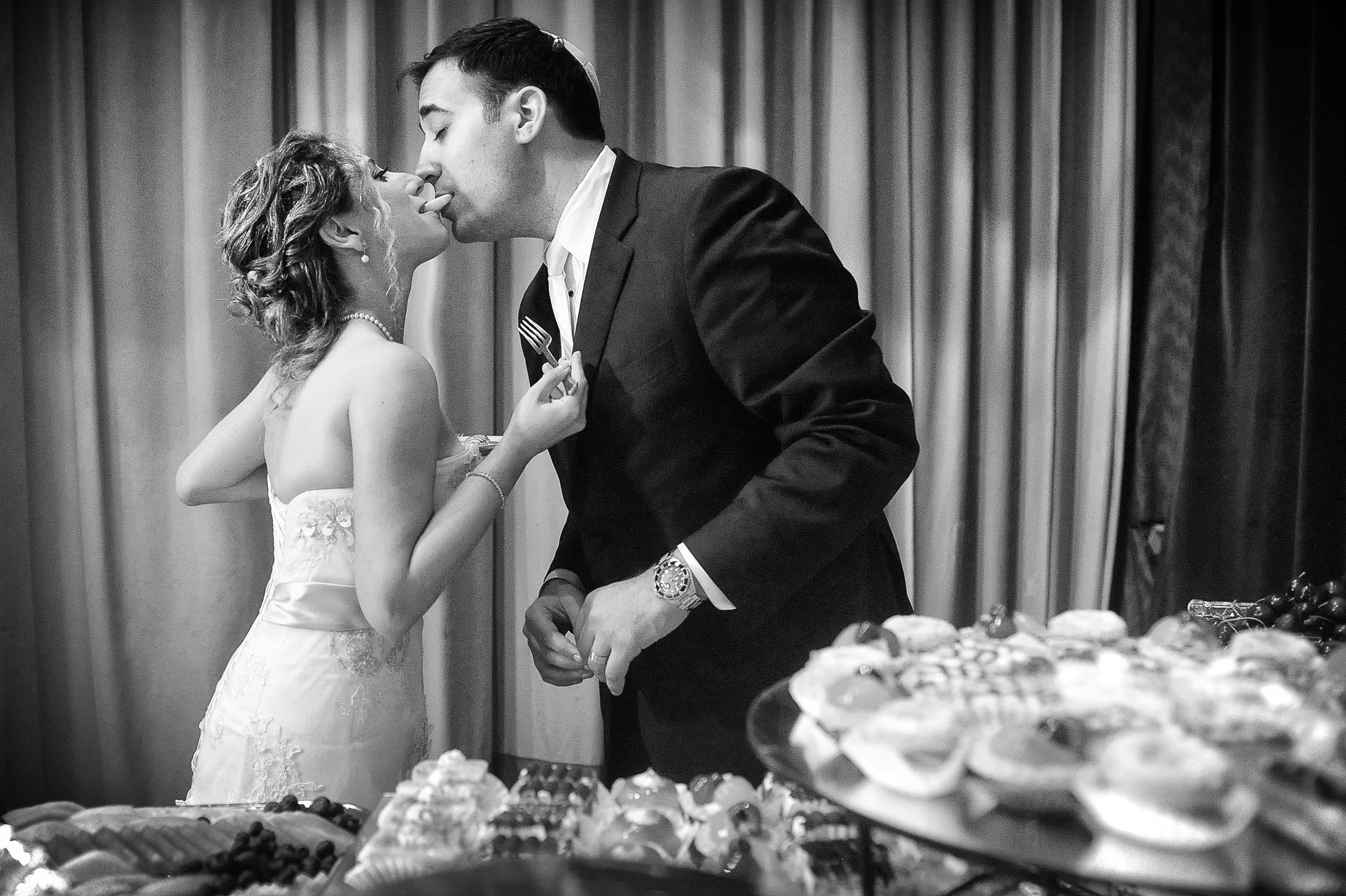 charming wedding reception bride groom eating one cookie together romantic black white shot by lavimage montreal