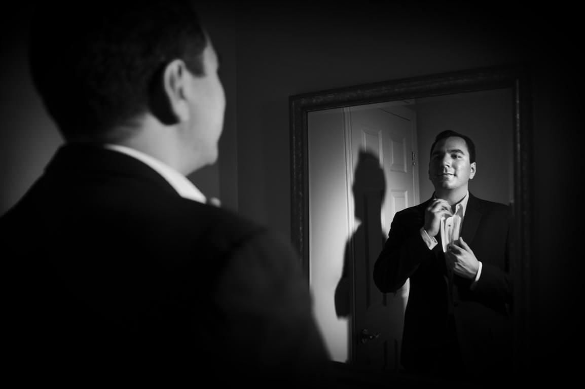 black and white wedding pictures getting ready groom facing mirror by lavimage montreal
