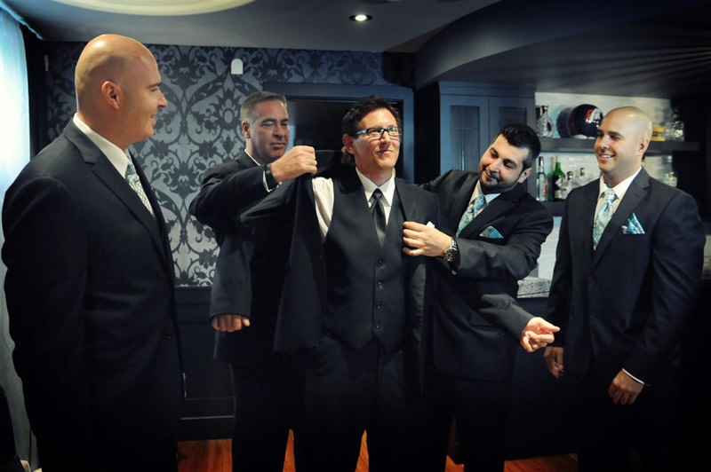 Grooms men helping the groom to get dressed  at the vineyard wedding photographed by La V image-Montreal wedding photographer