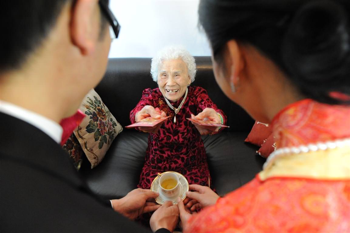 Parents at wedding-Tea ceremony grandmother gives a gift to the newlyweds by La V image Montreal wedding photographer